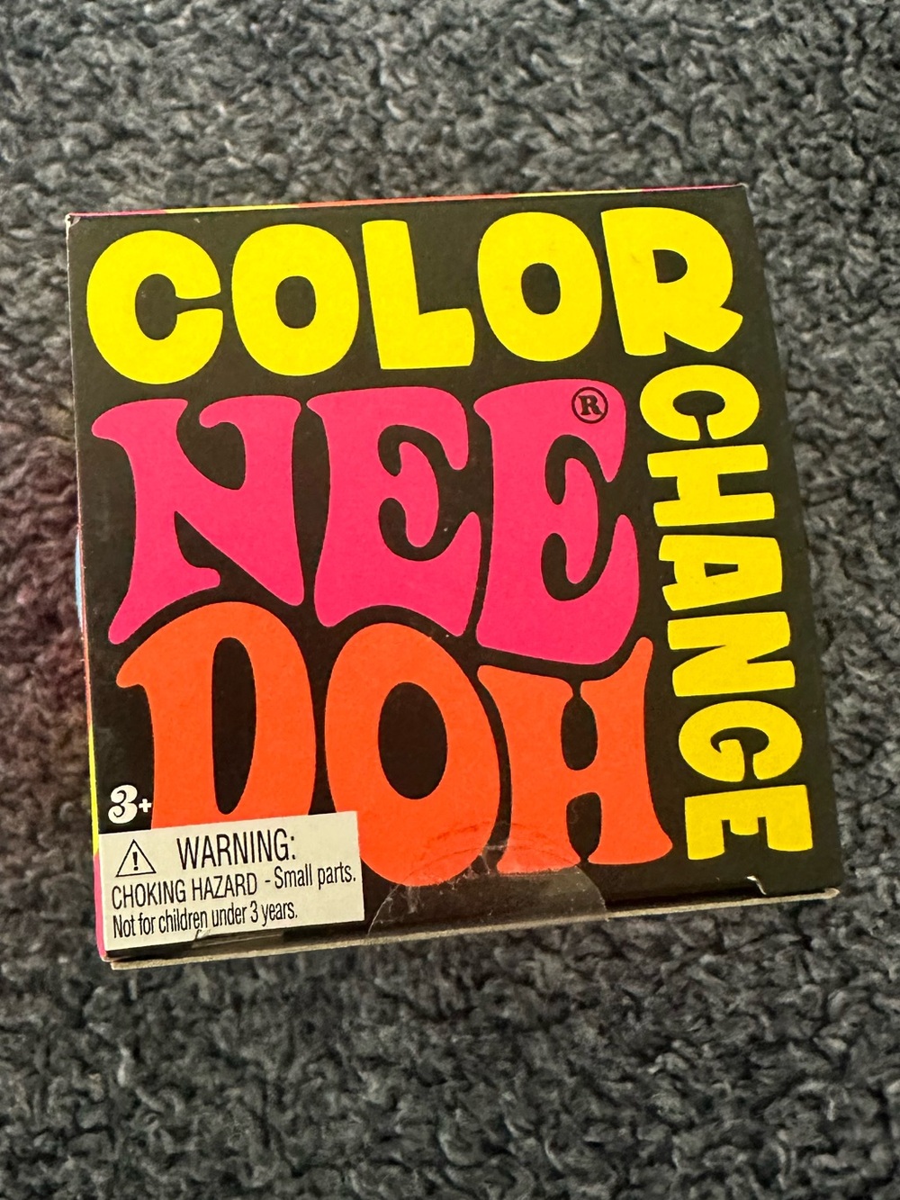 Color Nee-Doh Color Change Toy - Black Box with Yellow, Pink, Orange Text